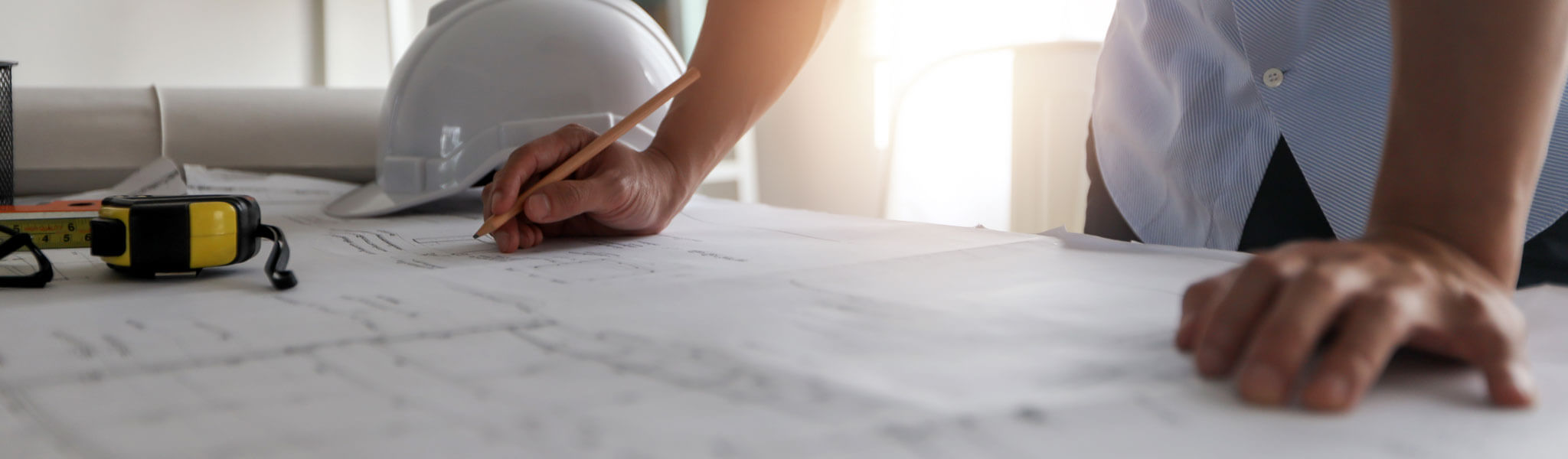 Close up hand of engineer draw and draft on blueprint on table